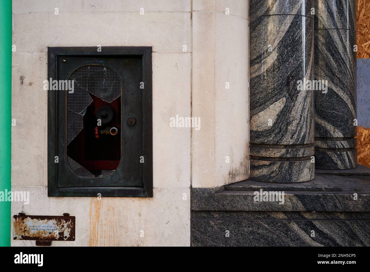 19 Feb 2023 - LondonUK : pannello di idrante in vetro rotto con motivo e parete in marmo Foto Stock