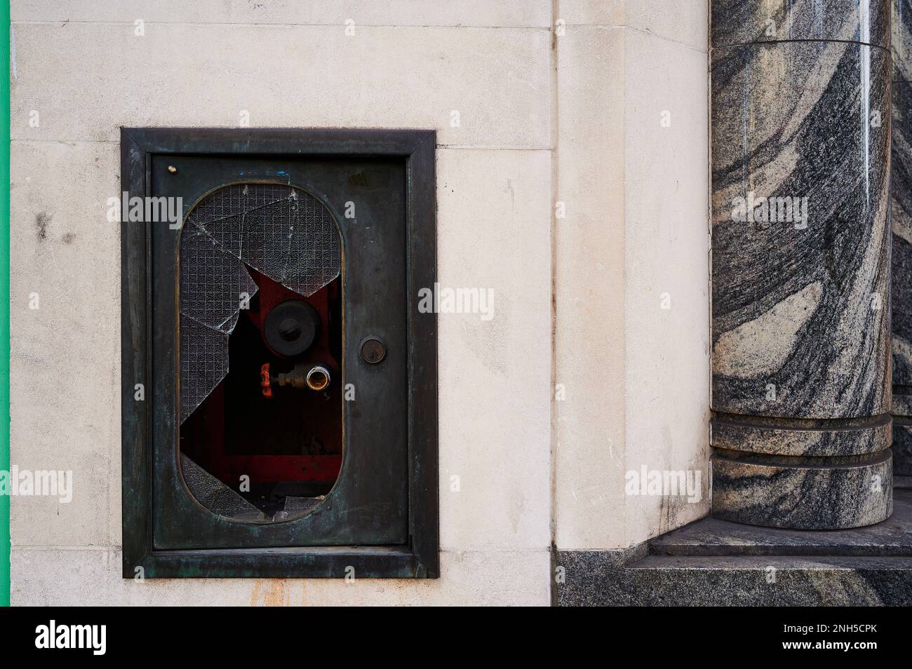 Pannello di idrante in vetro rotto con motivo e parete in marmo Foto Stock