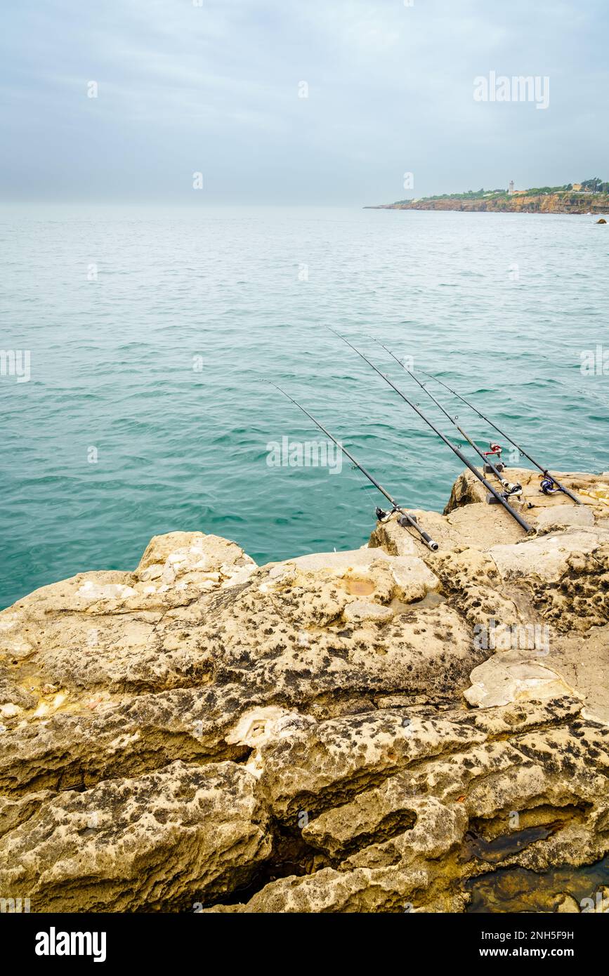Canne da pesca sulle rocce della costa di Cascais, Portogallo Foto Stock