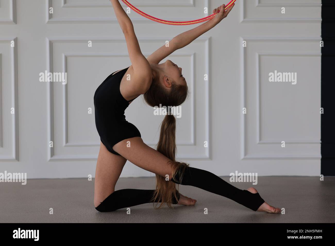 piccola ragazza dello sport che fa gli esercizi con un cerchio di hula Foto Stock