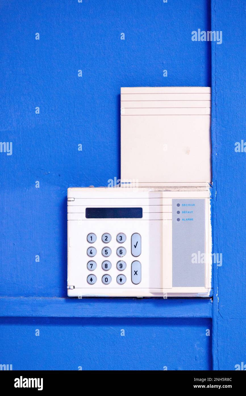 Sistema di allarme fissato su una parete blu. Foto Stock