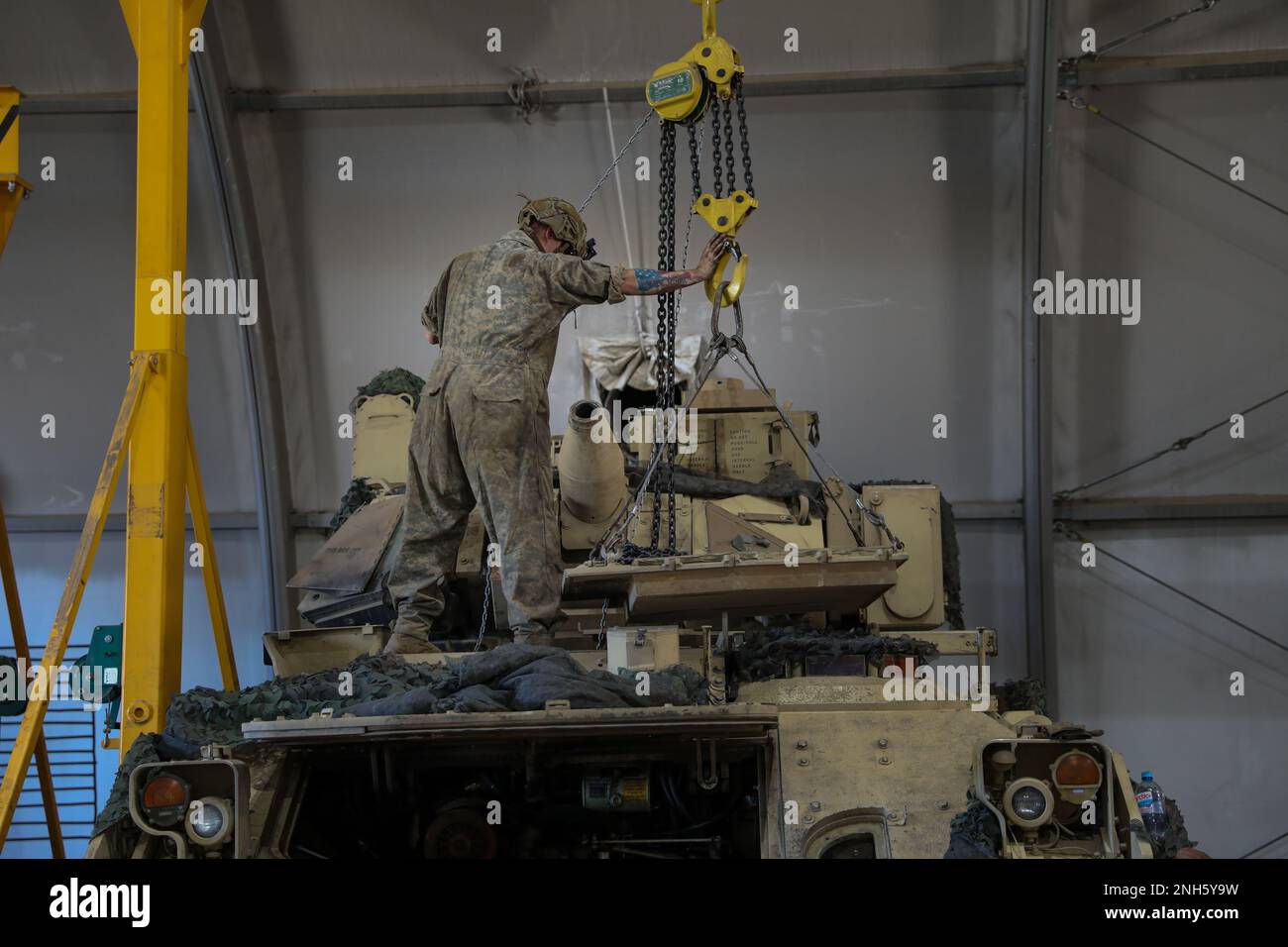 STATI UNITI Michael Nichols, un meccanico assegnato a Apache Troop, 4th Squadron, 10th Cavallery Regiment, 3rd Armored Brigade Combat Team, 4th Infantry Division, utilizza una gru per rimuovere il coperchio del motore di un veicolo da combattimento M2A3 Bradley durante i servizi annuali a Trzebień, Polonia, 18 luglio 2022. L'ABCT 3/4 è tra le altre unità assegnate alla Divisione Fanteria 1st, orgogliosamente lavorando insieme agli alleati della NATO e ai partner della sicurezza regionale per fornire forze credibili da combattimento al V Corps, il corpo americano schierato a termine in Europa. Foto Stock