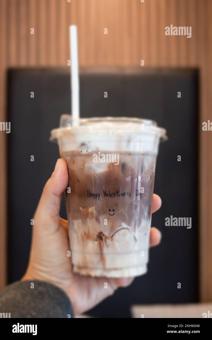 Tenere a mano il caffè mocha ghiaccio in un bicchiere con crema, foto di scorta Foto Stock