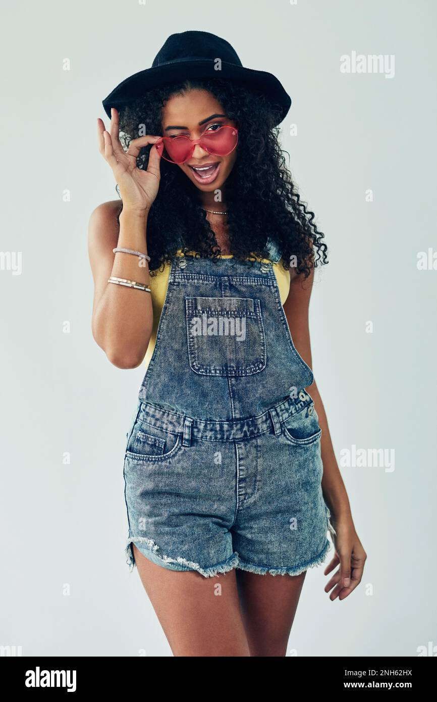 Sia bizzarro, sia casuale, sia chi siete. Studio di una giovane donna attraente che posa su uno sfondo grigio. Foto Stock