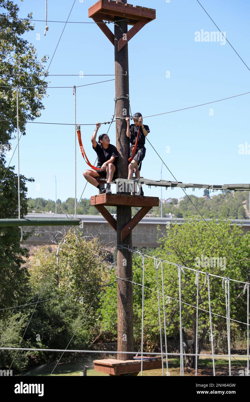 I candidati della Sunburst Youth Challenge Academy, Joint Forces Training base, California, fanno una pausa su una torre presso il corso Orange County Ropes di Anaheim, California, 19 luglio 2022. I candidati che si laureano a Sunburst guadagneranno un anno di crediti per la scuola superiore nel corso di cinque mesi e mezzo. Foto Stock