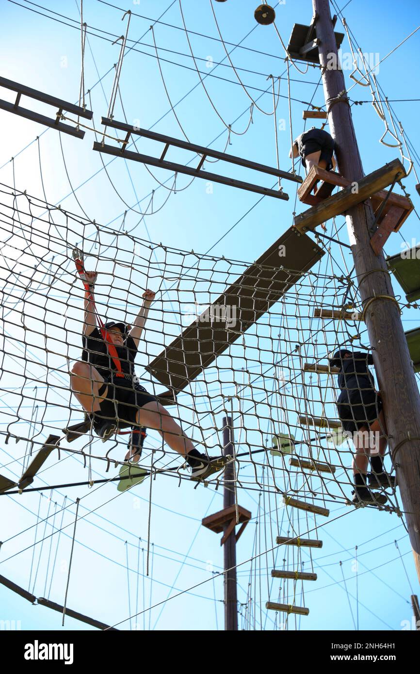 I candidati della Sunburst Youth Challenge Academy, Joint Forces Training base, California, manovrano attraverso un corso di corda al corso Orange County Ropes di Anaheim, California, 19 luglio 2022. Ogni candidato a Sunburst si è iscritto volontariamente per vari motivi, sia che si tratti di terminare la scuola superiore più velocemente o di uscire da difficoltà personali nella vita. Foto Stock