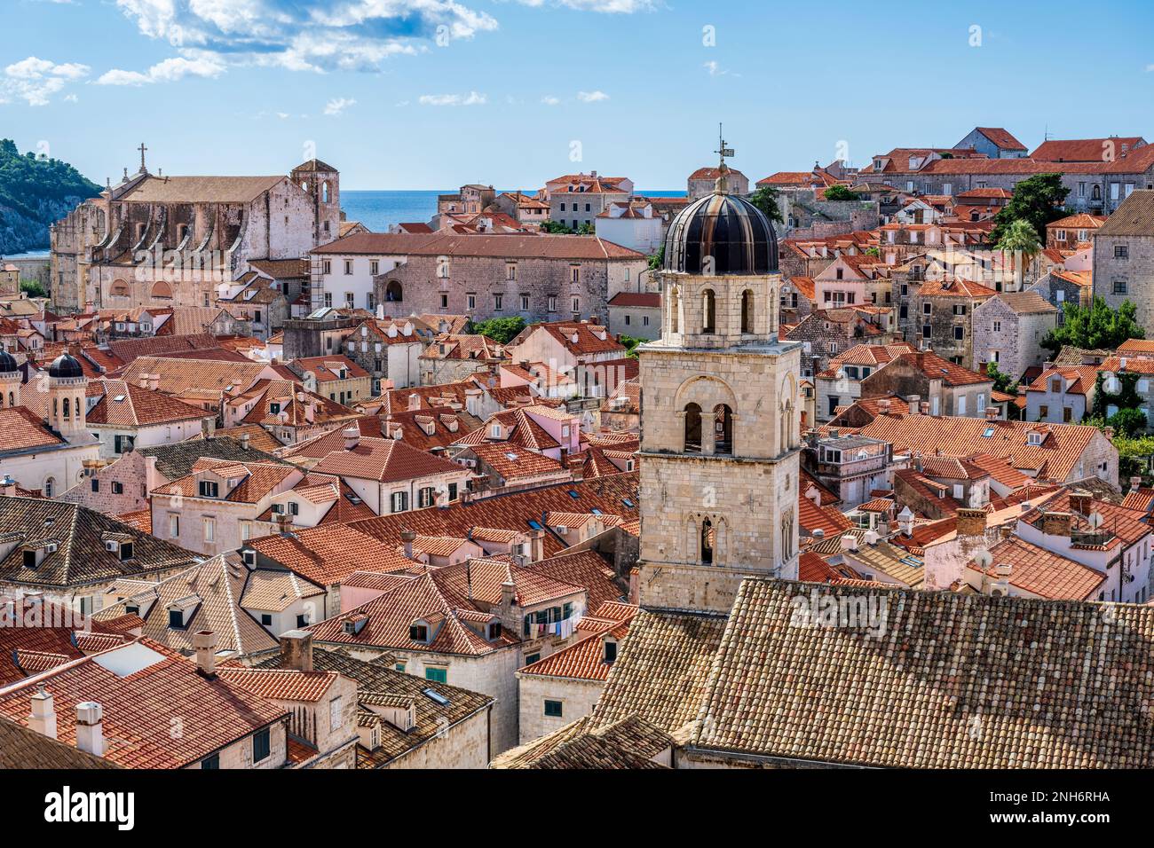 Vista attraverso i tetti di tegole rosse fino alla Chiesa di San Ignazio, con il campanile della Chiesa francescana sulla destra, nel centro storico di Dubrovnik in Croazia Foto Stock