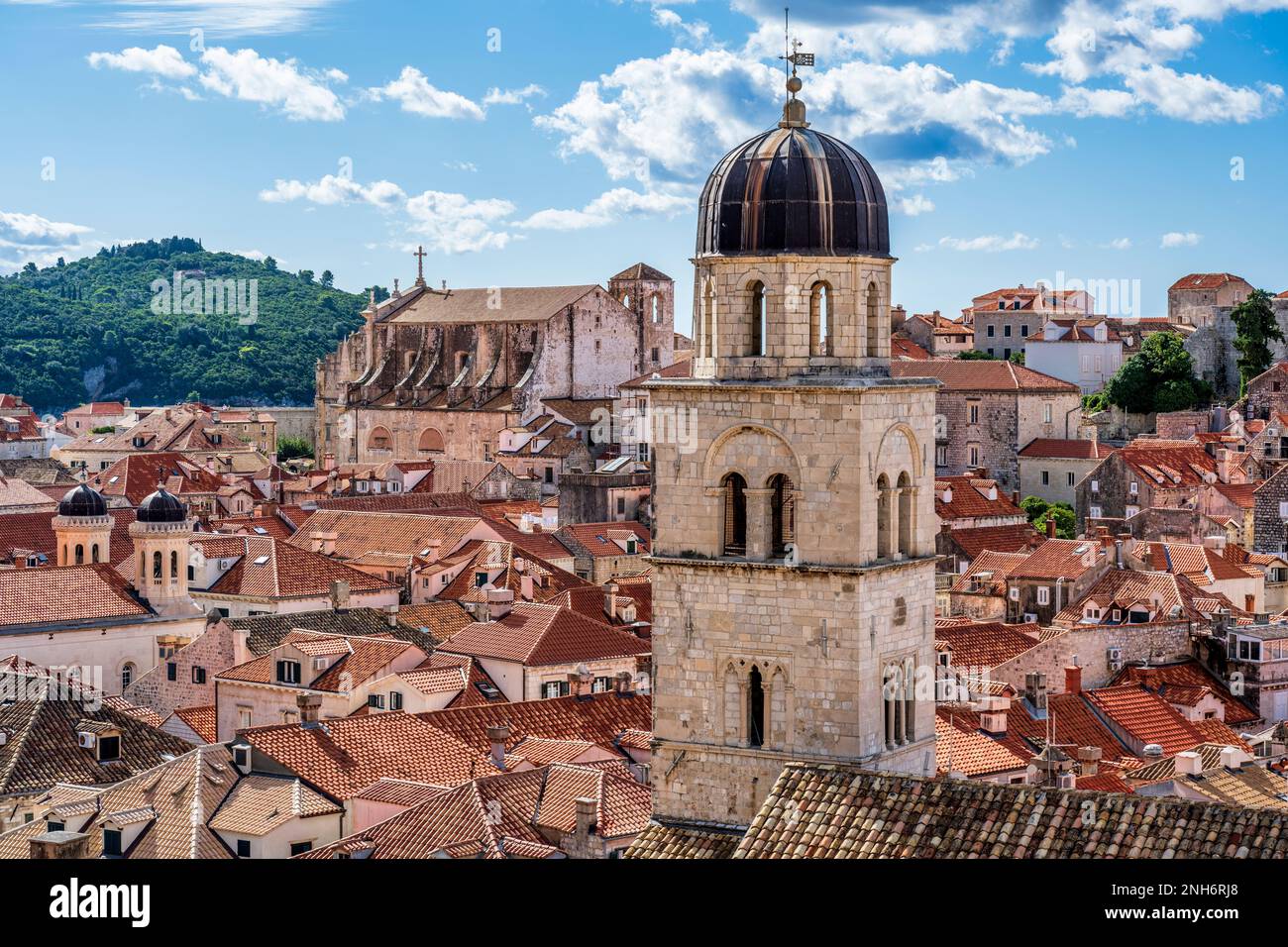 Vista attraverso i tetti di tegole rosse fino alla Chiesa di San Ignazio, con il campanile della Chiesa francescana sulla destra, nel centro storico di Dubrovnik in Croazia Foto Stock