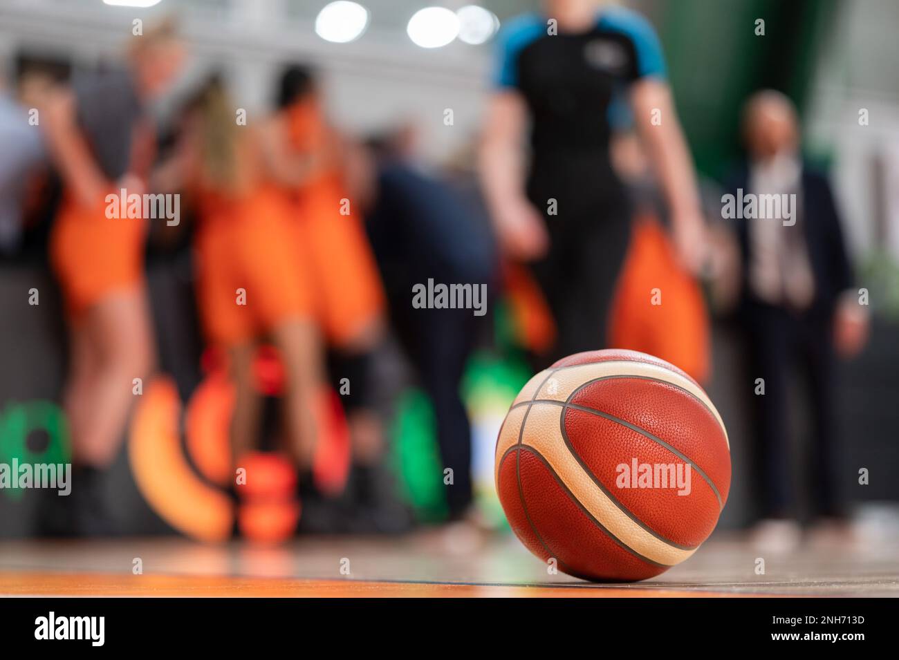 la palla giace sul parquet e la squadra di basket sullo sfondo. Foto Stock