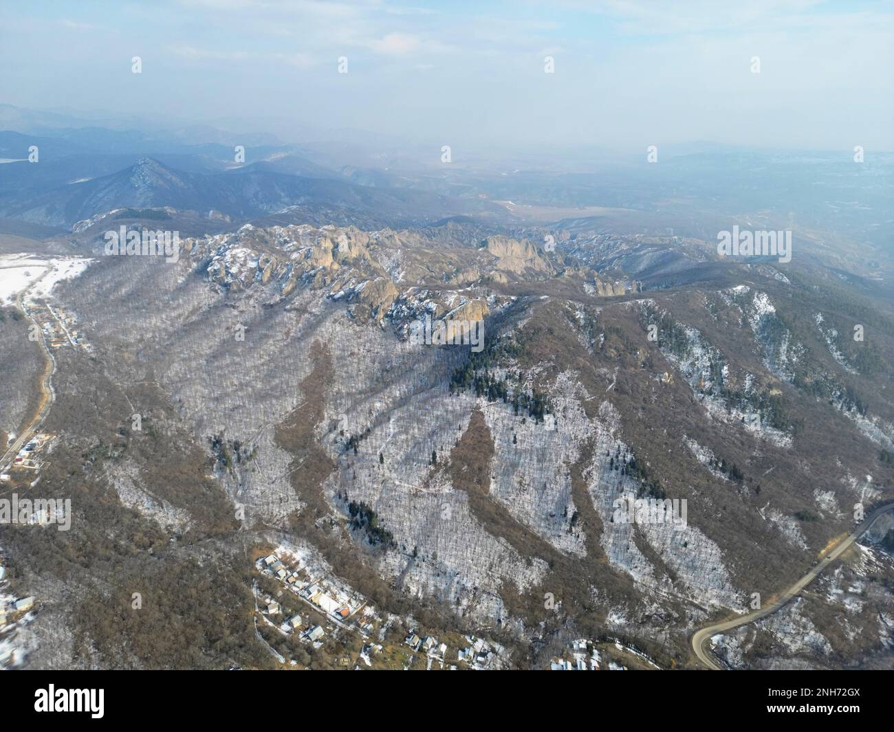 Veduta aerea delle montagne innevate e del paesaggio della valle sottostante, incontaminato dalla presenza umana Foto Stock