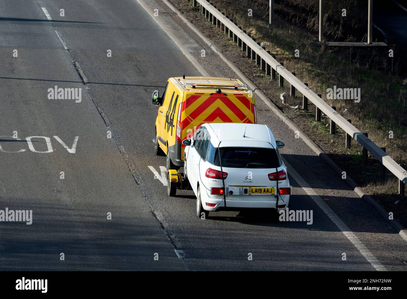 AA soccorso furgone trainante una macchina, Warwickshire, Inghilterra, Regno Unito Foto Stock