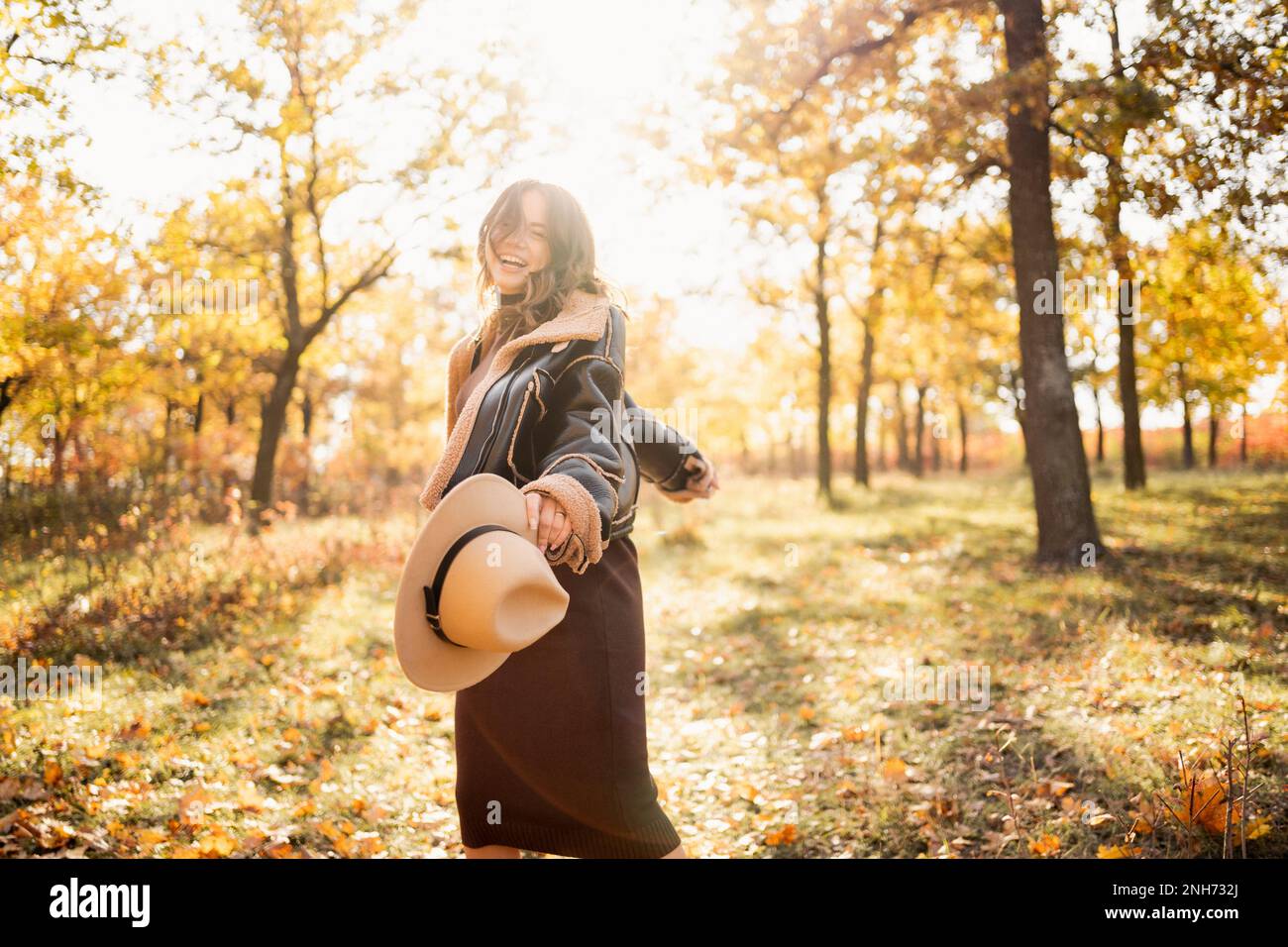 Donna felice che allunga le braccia respirando aria fresca godendo di libertà in una foresta in autunno. Spazio di copia Foto Stock