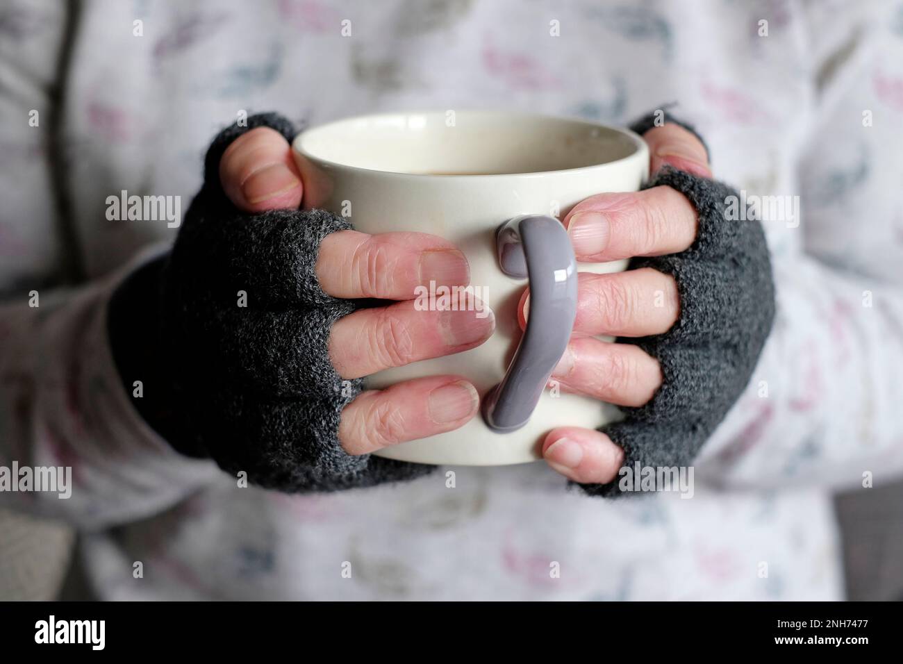 tazza con bevanda calda per mani anziane Foto Stock