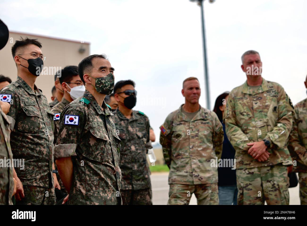 Il comandante dell'esercito della Repubblica di Corea del 5th il Gen. Kyu-Jun Lee ha visitato la Brigata dell'aviazione di combattimento del 2nd il 20 luglio 2022 per ricevere un brief sulle capacità dell'AH-64E V6 e dell'aquila grigia mq-1C. Il Lt. Gen. Lee si trova davanti al suo staff mentre viene informato su questi aerei e sulle loro capacità di squadra con equipaggio senza equipaggio. Foto Stock