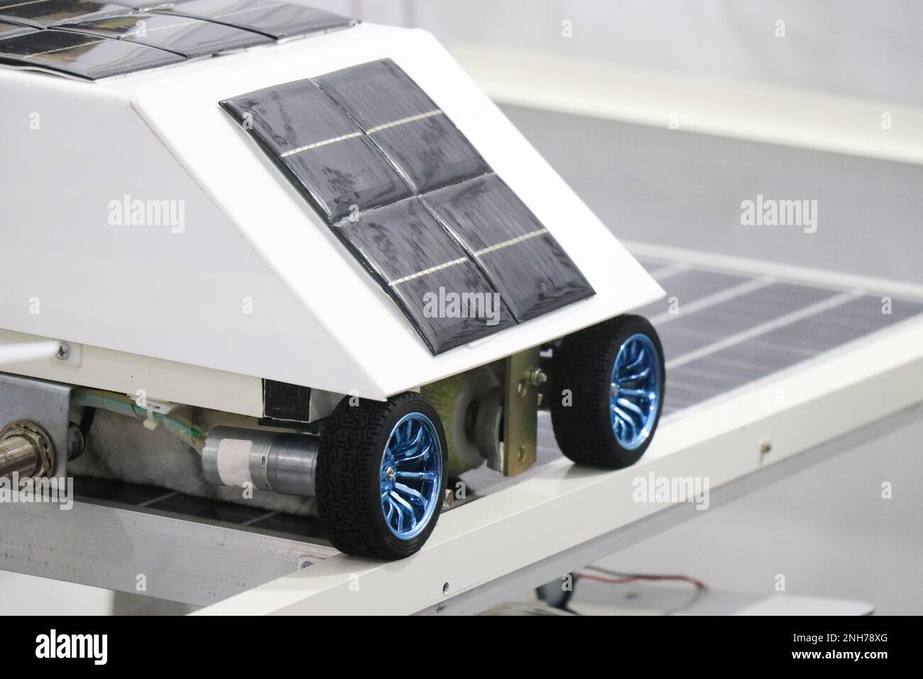 Prototipo di un piccolo rover meccanico che gira su ruote collegate a un motore CC e alimentato dal sole utilizzando più pannelli solari Foto Stock