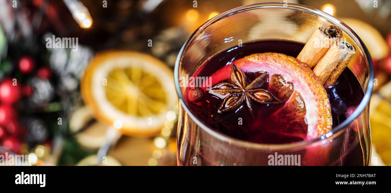 Primo piano di Natale in pacciamatura, vino rosso con spezie e frutta arance su un tavolo rustico in legno con rami di abete nuovo anno. Tradizionale chr. Caldo Foto Stock