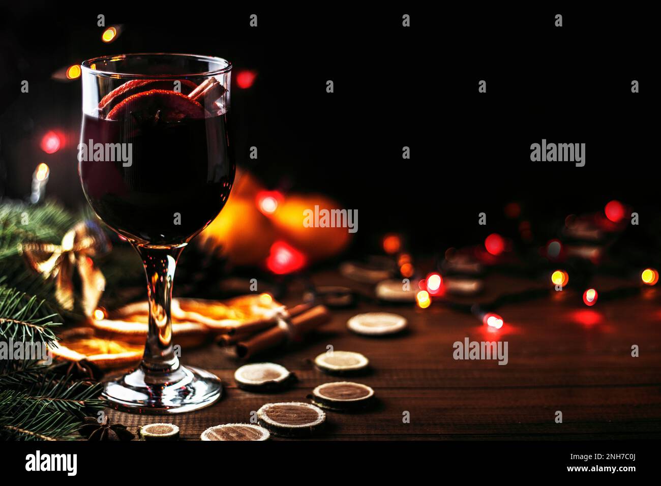 Natale mulled in un bicchiere, vino rosso con spezie e frutta arance su un tavolo rustico in legno con rami di abete nuovo anno. Tradizionale caldo natale dr Foto Stock