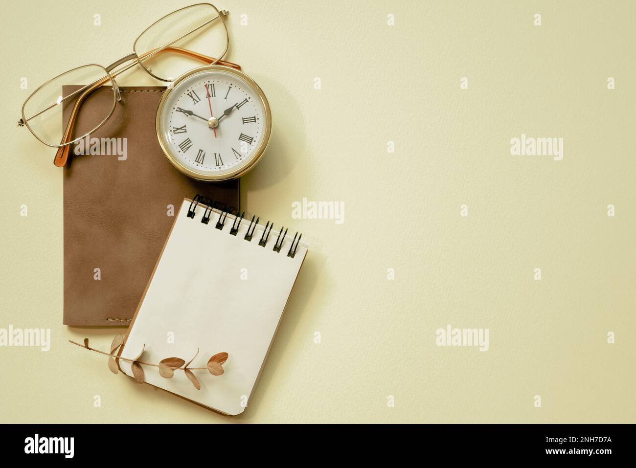 Blocco note, diario, orologio, occhiali su sfondo giallo scrivania. disposizione a fieno, vista dall'alto, spazio di copia Foto Stock