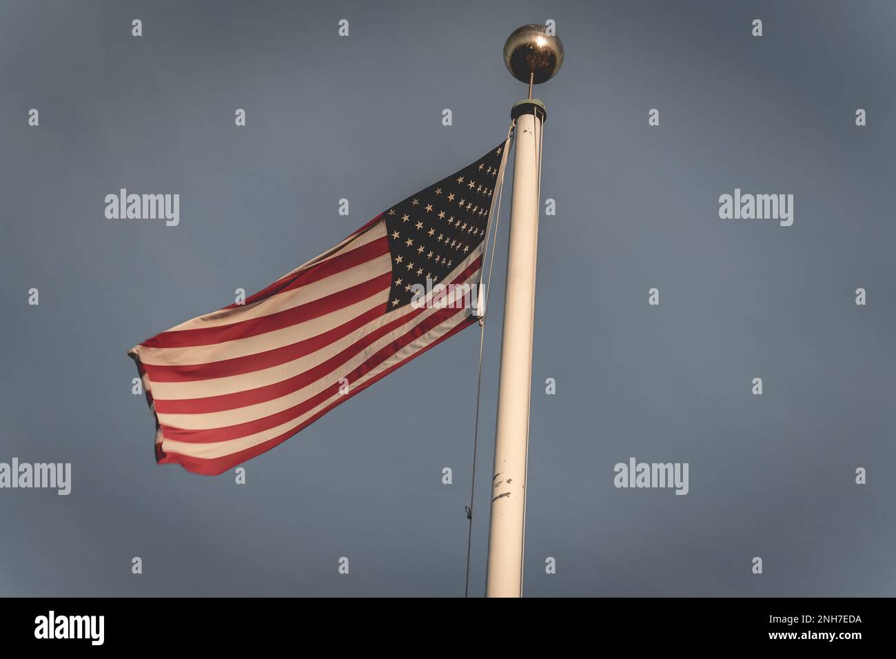 Bandiera americana che sventola al vento, al cimitero americano di Magraten, nei Paesi Bassi. Foto Stock