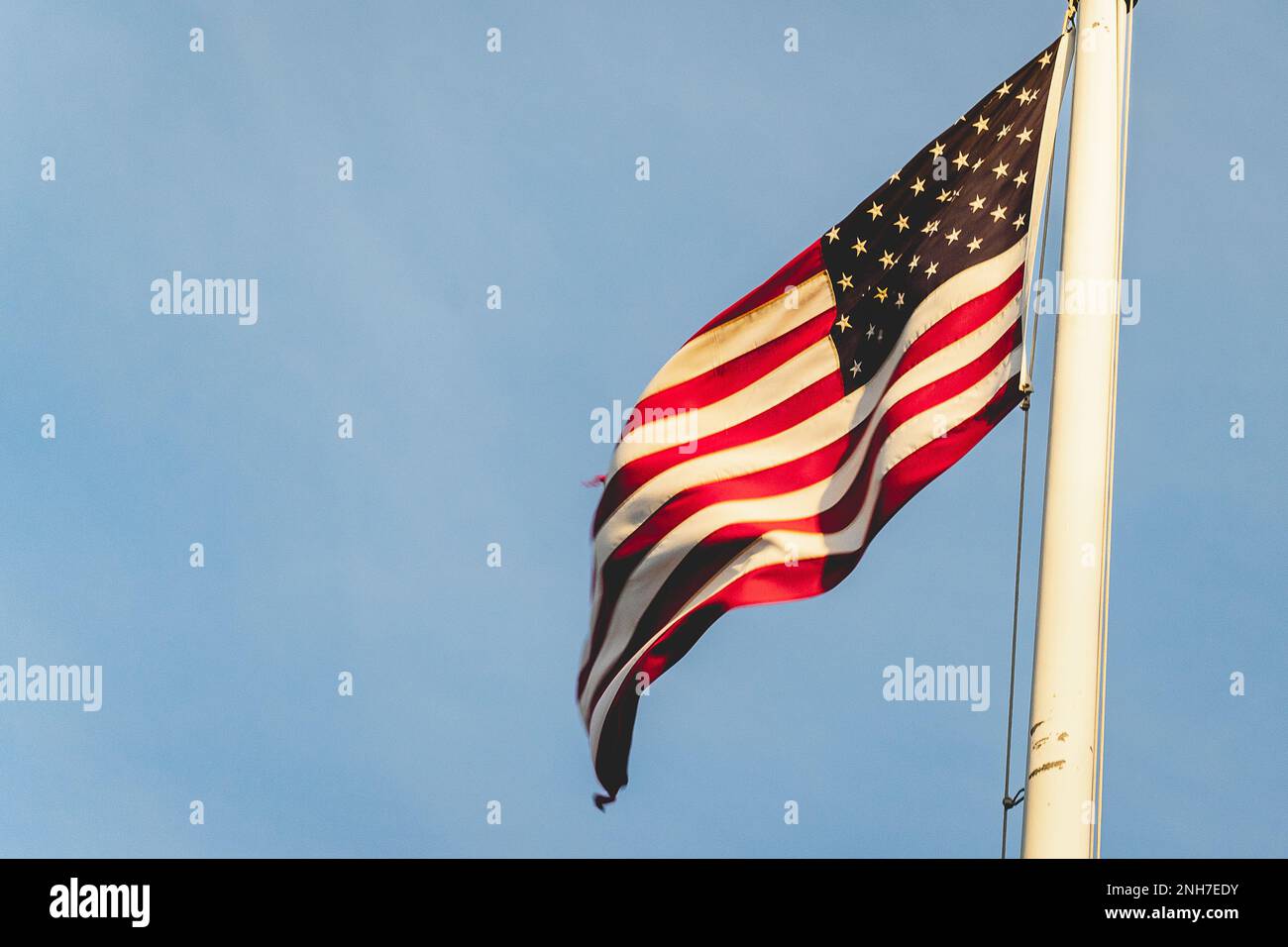 Bandiera americana che sventola al vento, al cimitero americano di Magraten, nei Paesi Bassi. Foto Stock