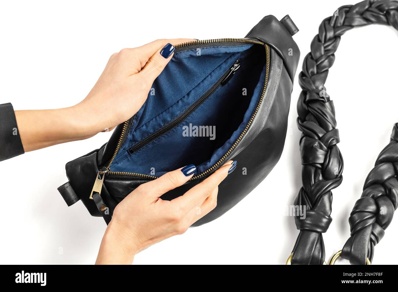 Borsa a tracolla in vera pelle nera con apertura a mani femminili e Fodera interna in tessuto blu. Produzione di articoli in pelle fatti a mano Foto Stock