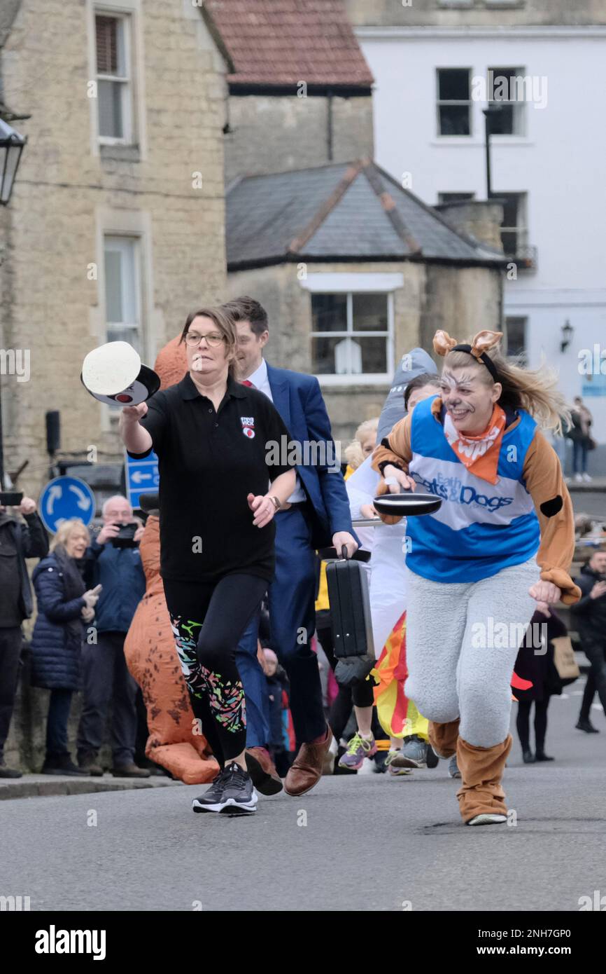 Bradford-on Avon, Wiltshire, Regno Unito. 21st Feb, 2023. La corsa annuale dei pancake lungo il ponte cittadino nello storico Bradford-on-Avon del Wiltshire. La strada principale è chiusa per alcuni minuti ogni martedì Shrove per questa tradizionale gara leggera; il percorso è sopra il ponte e di nuovo indietro. Ogni frittella deve essere gettata almeno tre volte lungo il percorso, altrimenti il concorrente viene squalificato. Il martedì di Shrove è una festa cristiana prima dell'inizio della Quaresima, un'occasione per usare i grassi e gli zuccheri prima del digiuno. Credit: JMF News/Alamy Live News Foto Stock