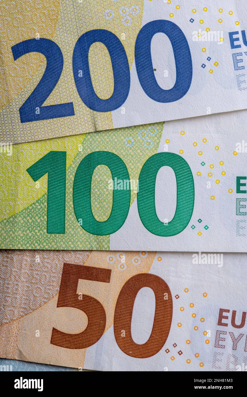 Diverse banconote in euro in fila primo piano, sfondo blu per i temi di finanza aziendale. Concetto di denaro mondiale, concetto di inflazione ed economia. Valuta Foto Stock