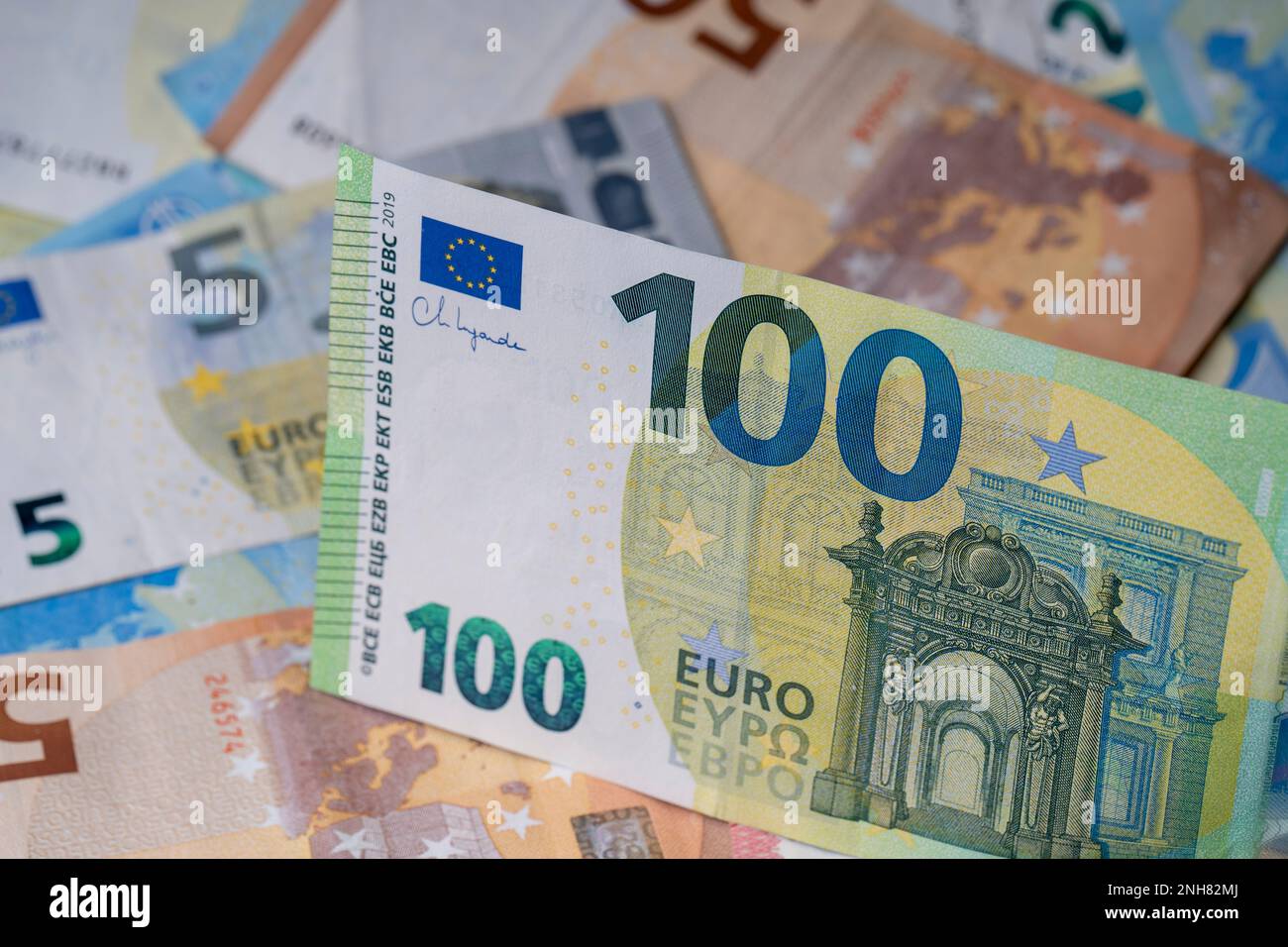 Una pila di banconote sul tavolo. Cento euro di carta moneta in primo piano. Banconote miste in euro in background. Foto Stock