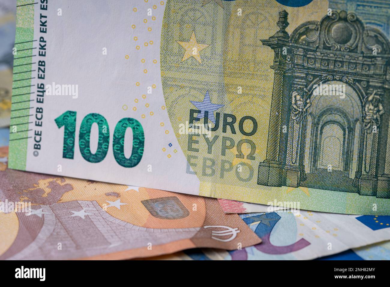 Una pila di banconote sul tavolo. Cento euro di carta moneta in primo piano. Banconote miste in euro in background. Foto Stock