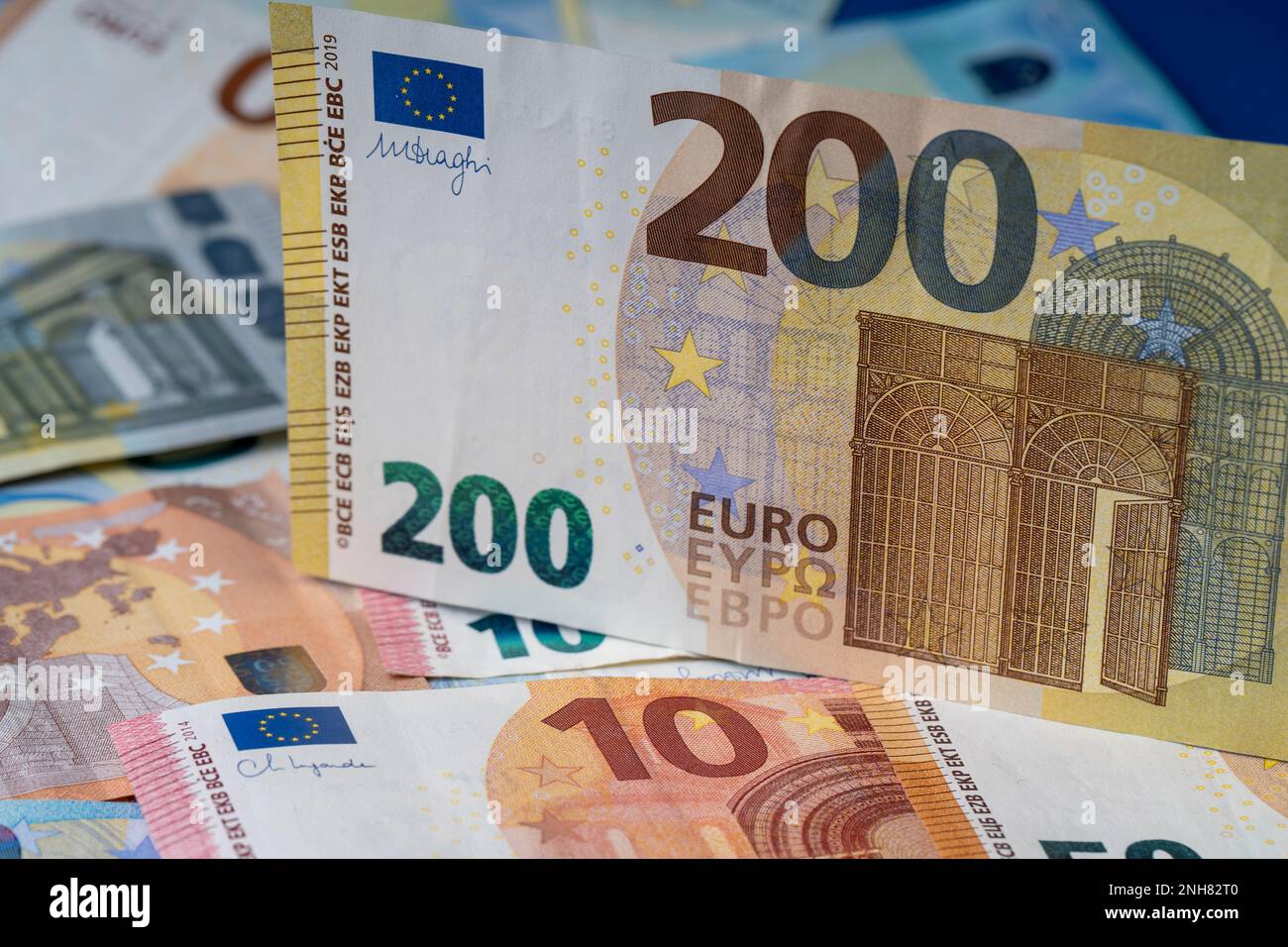 Una pila di banconote sul tavolo. Duecento euro di carta moneta in primo piano. Banconote miste in euro in background. Foto Stock