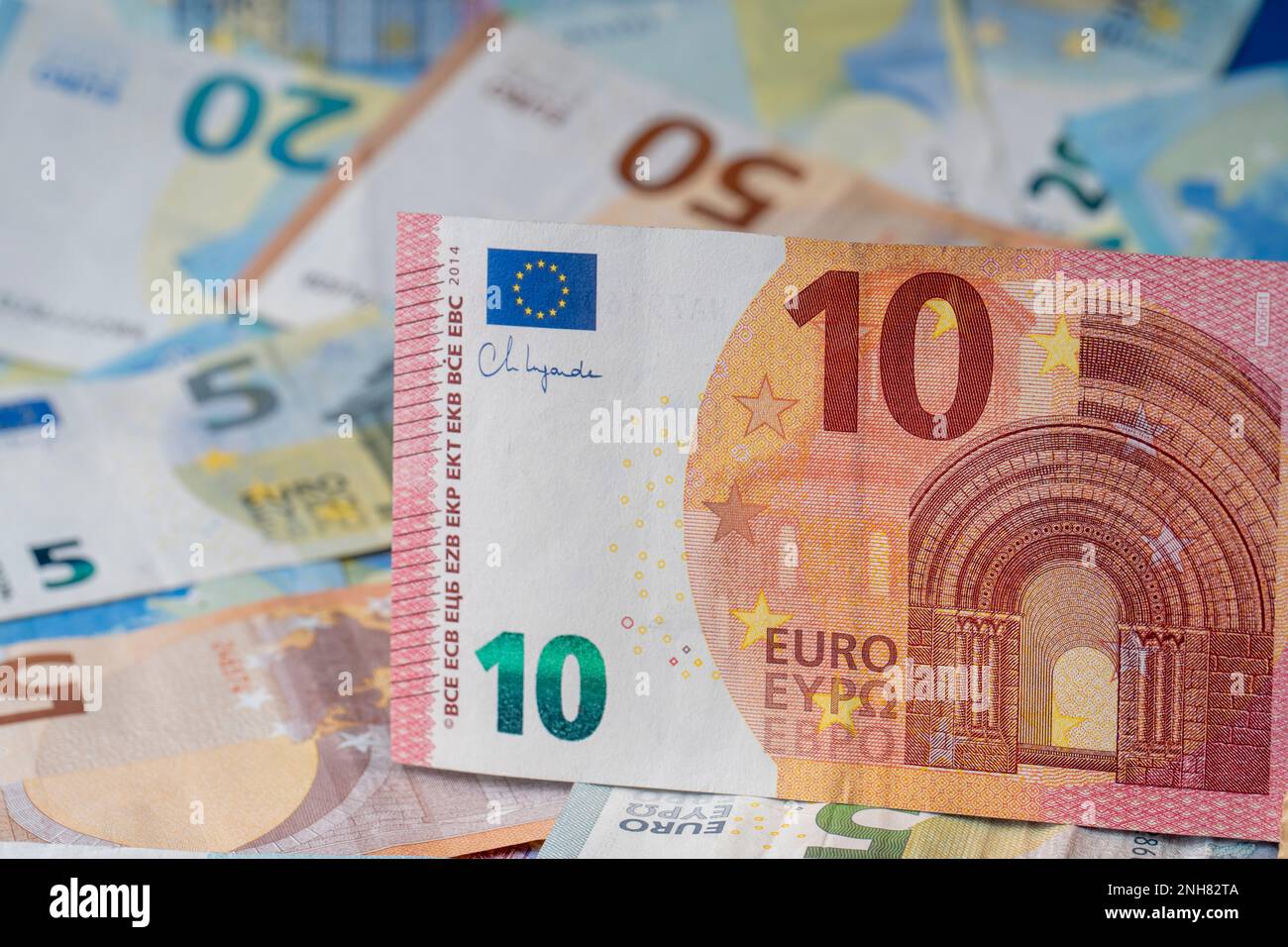 Una pila di banconote sul tavolo. Dieci euro di carta moneta in primo piano. Banconote miste in euro in background. Foto Stock