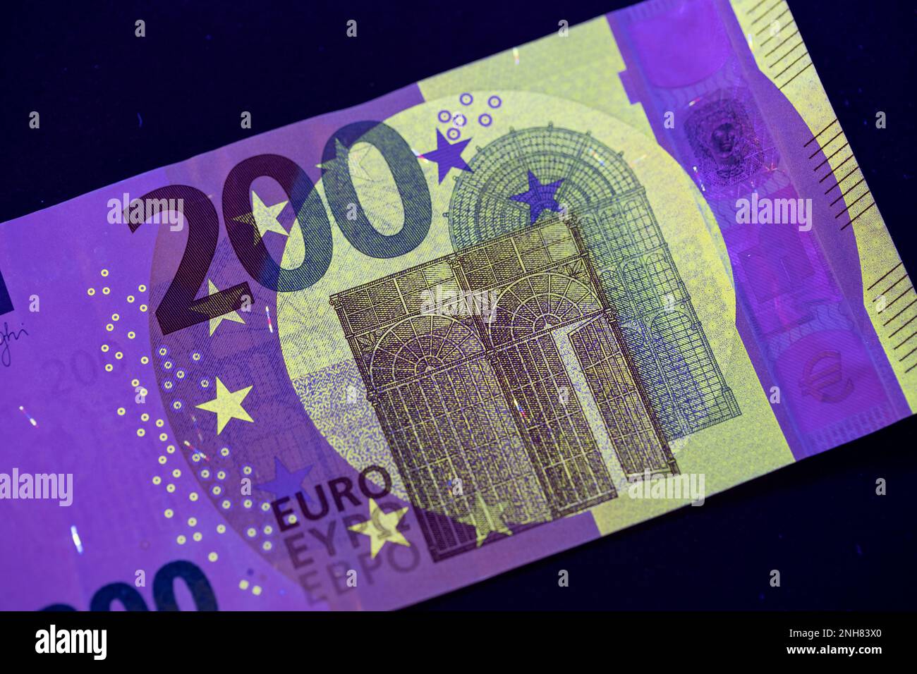 Valuta europea in protezione dalla luce UV. Euro in luce UV per controllare l'autenticità del denaro. Foto Stock
