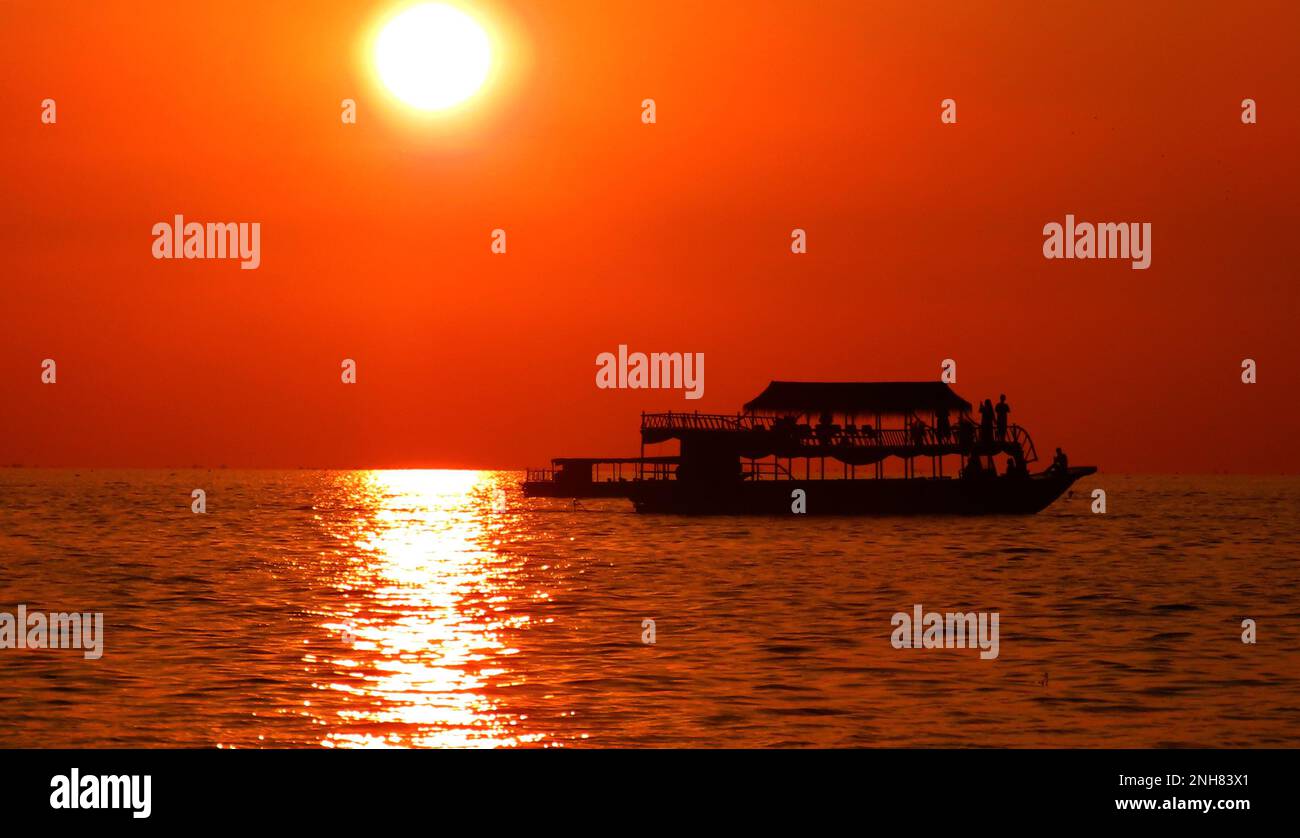 Battello sul fiume Cambogiano al tramonto Foto Stock