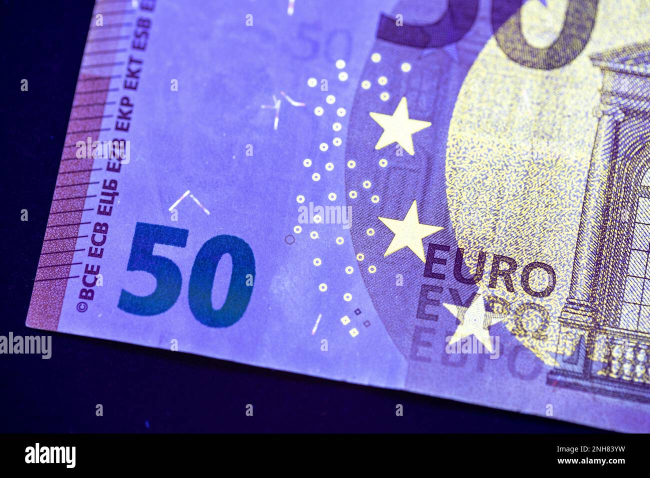 Valuta europea in protezione dalla luce UV. Euro in luce UV per controllare l'autenticità del denaro. Foto Stock