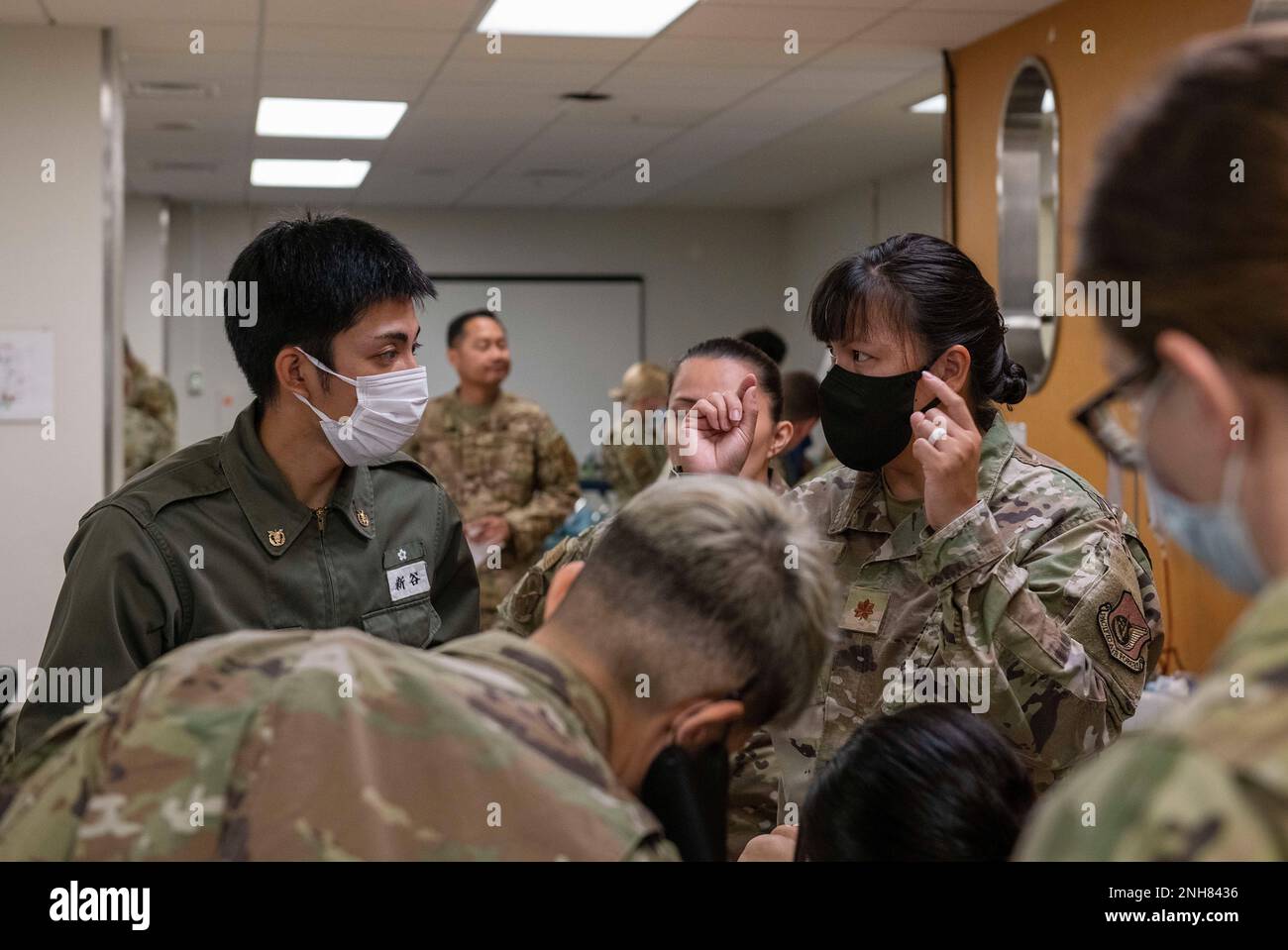 Sheryll Ann Frias, 374th° comandante di unità multi-servizio del gruppo medico, spiega le procedure mediche a uno studente del National Defense Medical College durante un'immersione di studenti di infermieri giapponesi, il 21 luglio 2022, presso la base aerea di Yokota, Giappone. Gli infermieri sono stati in grado di sperimentare una giornata di formazione completa del programma di preparazione medica (CMRP), inclinando le competenze di varie apparecchiature per includere pompe IV, un rapido infusore, procedure CPR e altro ancora. Foto Stock