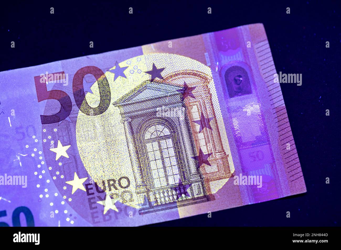 Valuta europea in protezione dalla luce UV. Euro in luce UV per controllare l'autenticità del denaro. Foto Stock
