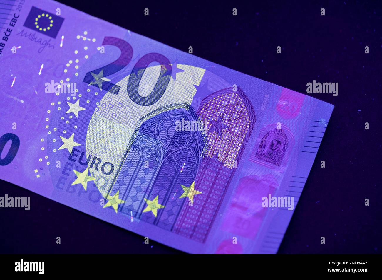 Valuta europea in protezione dalla luce UV. Euro in luce UV per controllare l'autenticità del denaro. Foto Stock