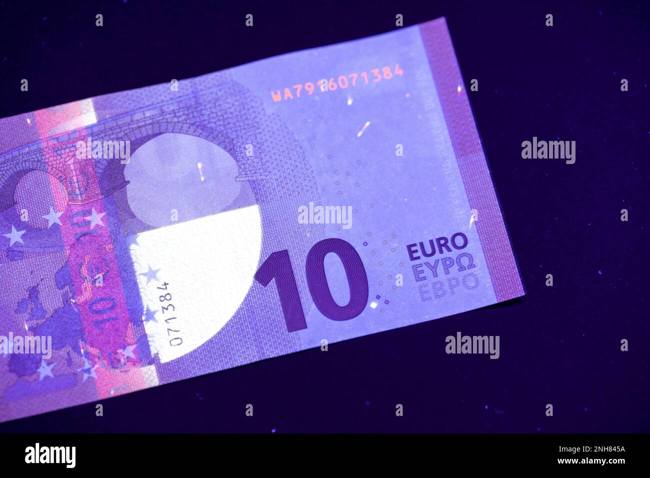 Valuta europea in protezione dalla luce UV. Euro in luce UV per controllare l'autenticità del denaro. Foto Stock