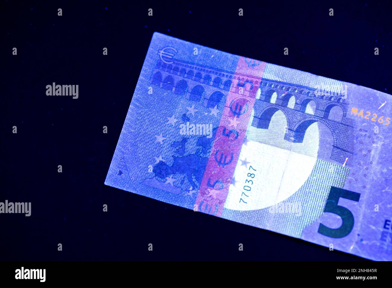 Valuta europea in protezione dalla luce UV. Euro in luce UV per controllare l'autenticità del denaro. Foto Stock
