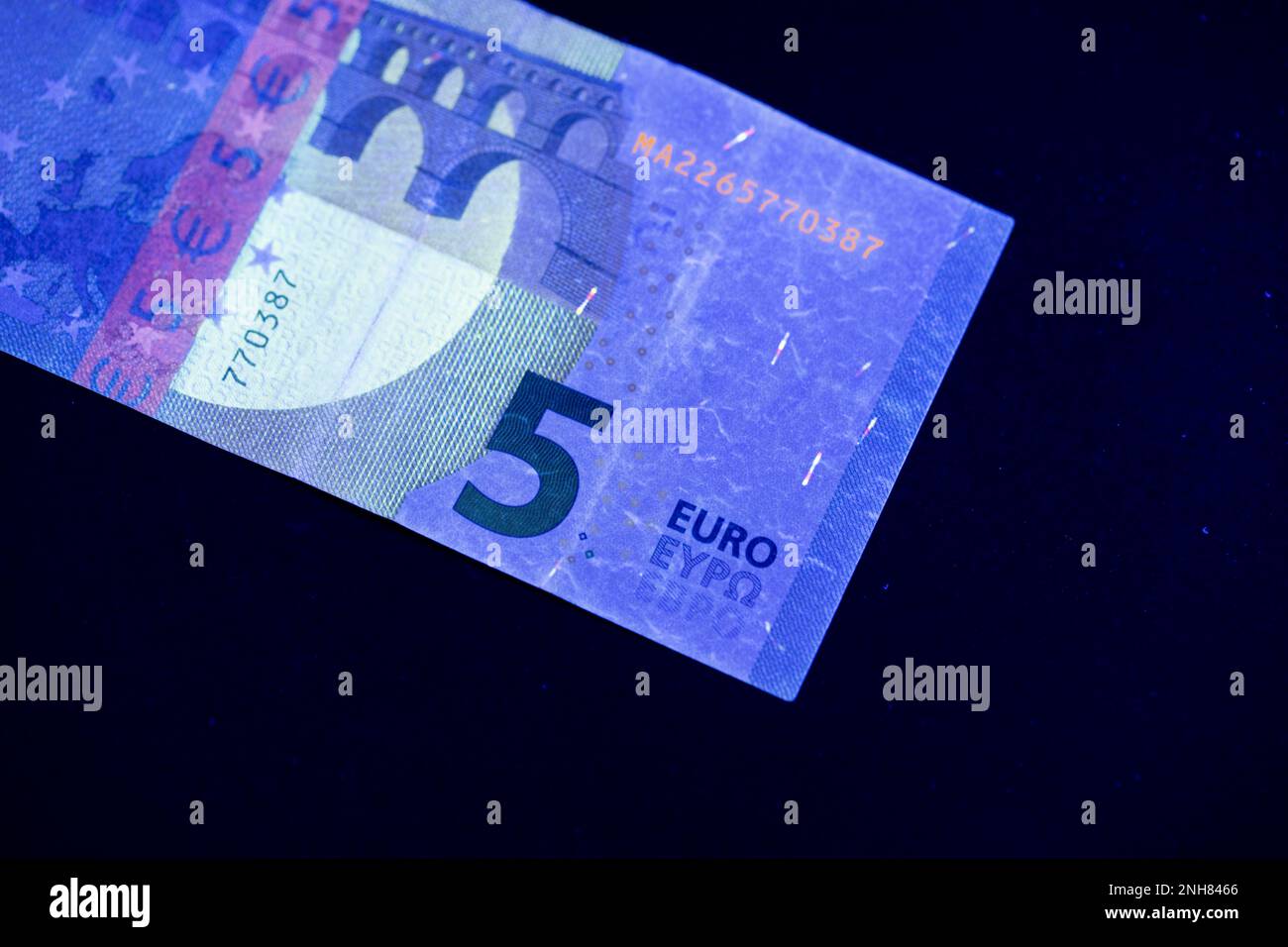 Valuta europea in protezione dalla luce UV. Euro in luce UV per controllare l'autenticità del denaro. Foto Stock
