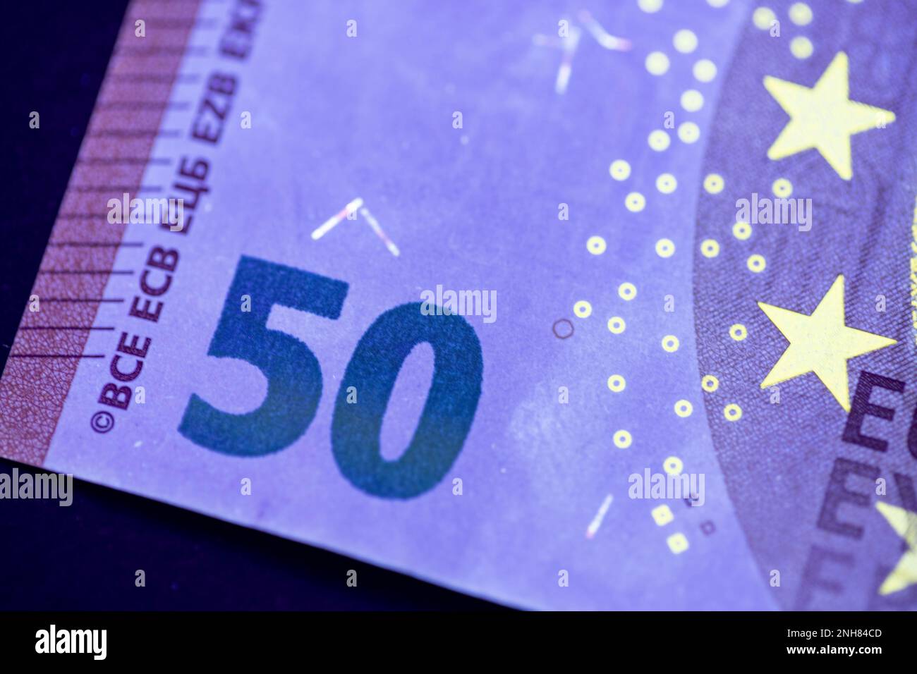 Valuta europea in protezione dalla luce UV. Euro in luce UV per controllare l'autenticità del denaro. Foto Stock