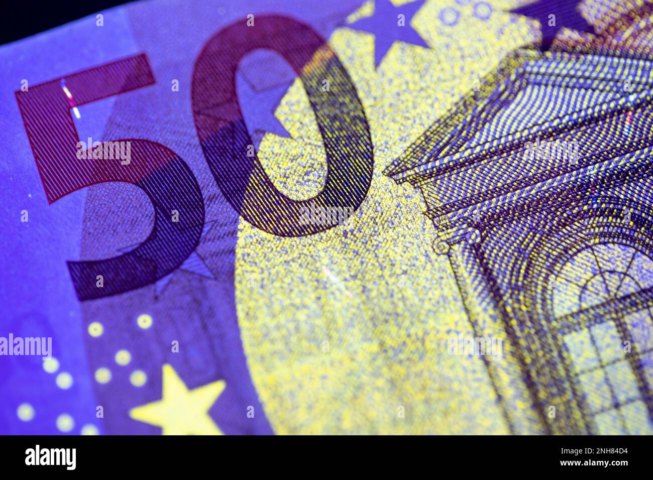 Valuta europea in protezione dalla luce UV. Euro in luce UV per controllare l'autenticità del denaro. Foto Stock