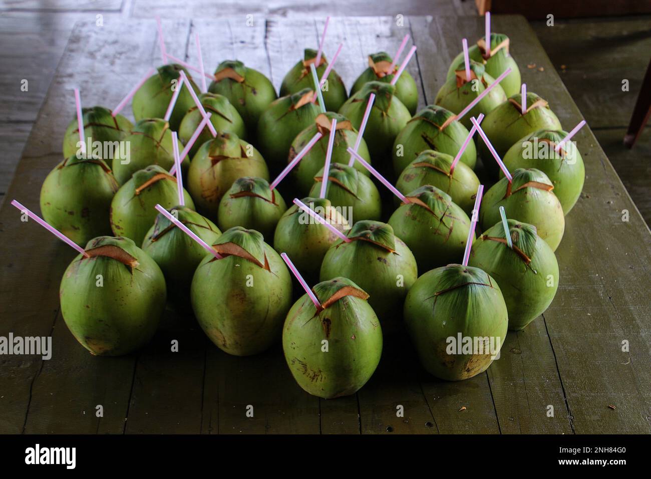 Noci di cocco verdi con cannucce di plastica pronte da bere da Ninh Kieu, Can Tho, Vietnam Foto Stock