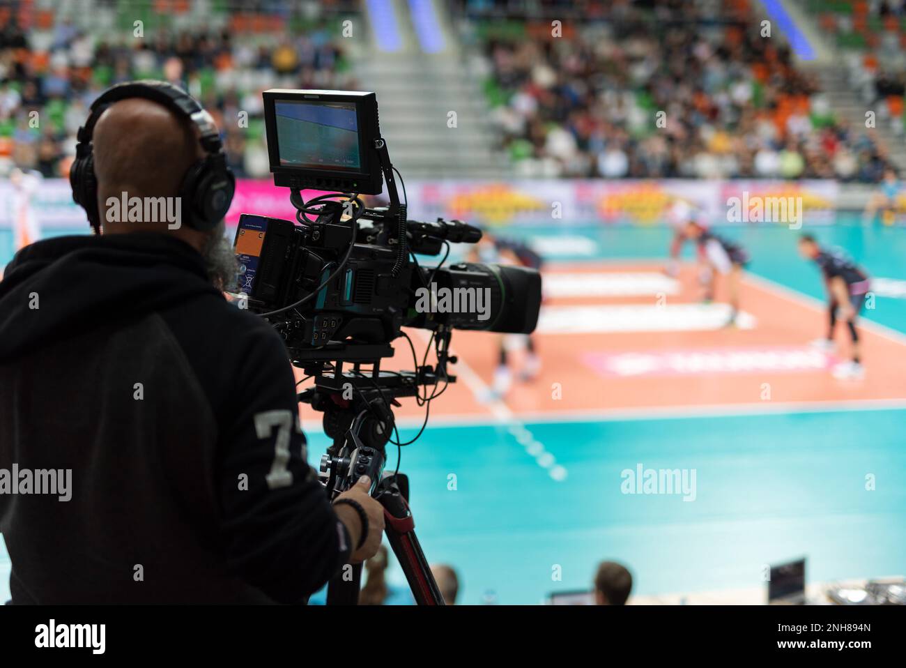 Telecamera professionale con partita di pallavolo sullo sfondo. Foto Stock