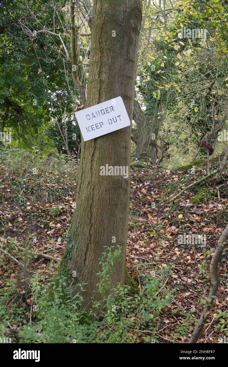 Pericolo tenere fuori segno inchiodato a un tronco d'albero Foto Stock