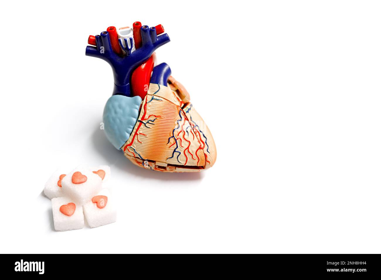 Cubetto di zucchero con cuore rosso e modello di cuore su sfondo bianco. concetto di medicina. concetto di diabete Foto Stock