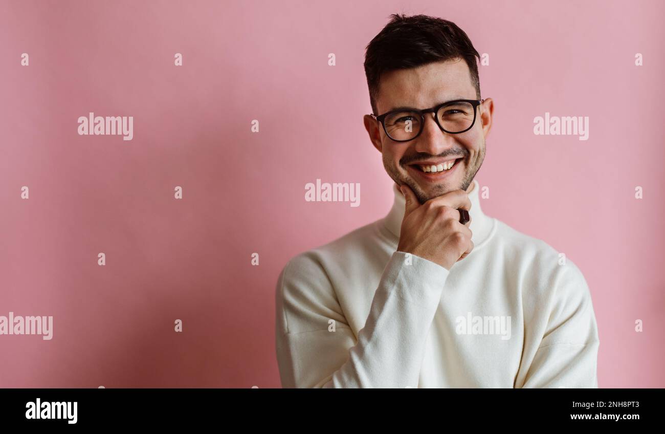 Ritratto di felice uomo bearded che indossa gli occhiali ridendo e guardando la macchina fotografica mentre si posa Foto Stock