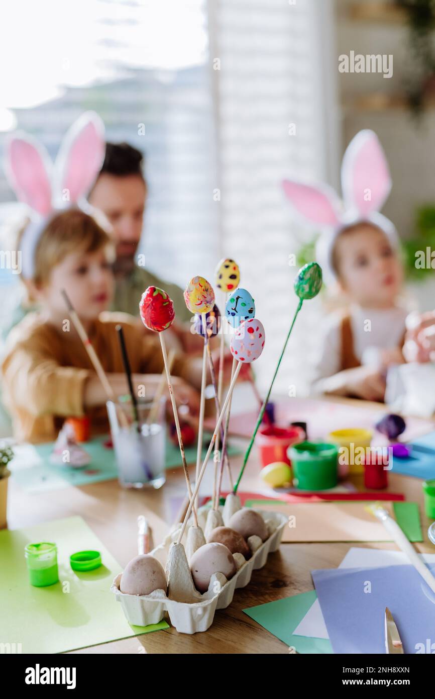 Buon padre con i bambini che decorano le uova di pasqua. Foto Stock