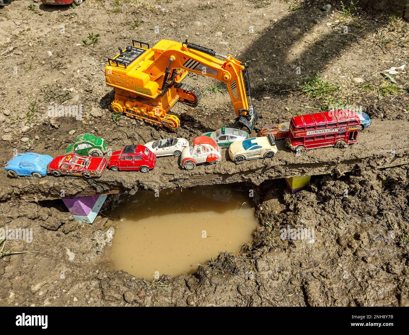 macchine giocattolo su un mini ponte realizzato da un ragazzo. i bambini giocano Foto Stock