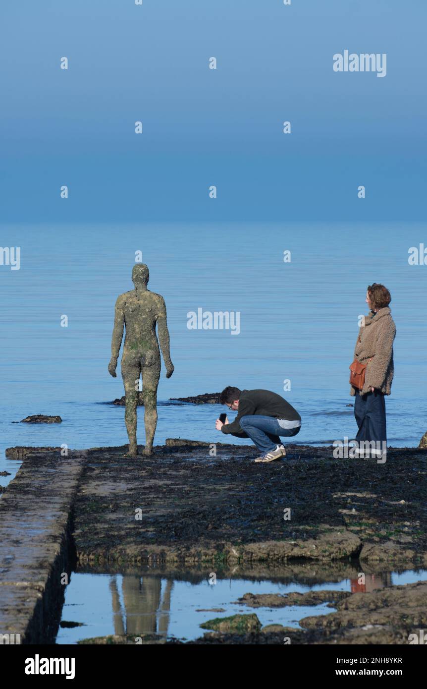 I visitatori di margate, Kent, fotografano la scultura di Antony Gormley nella baia Foto Stock